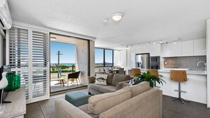 A modern apartment with a living area, kitchen, and balcony. - Mylos Holiday Apartments (Maroochydore)