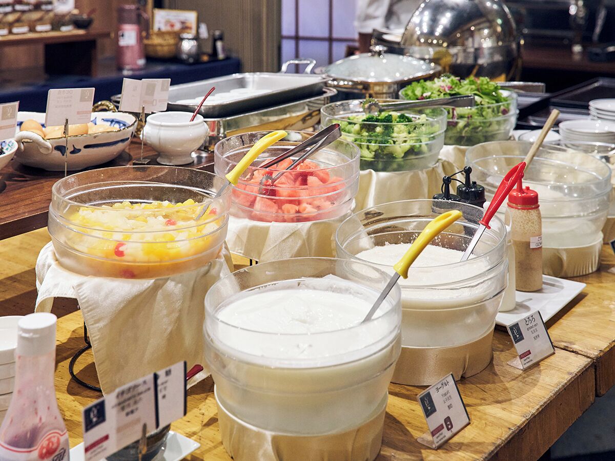 A buffet with various food and drink options, including bowls of soup, salads, and a variety of beverages.