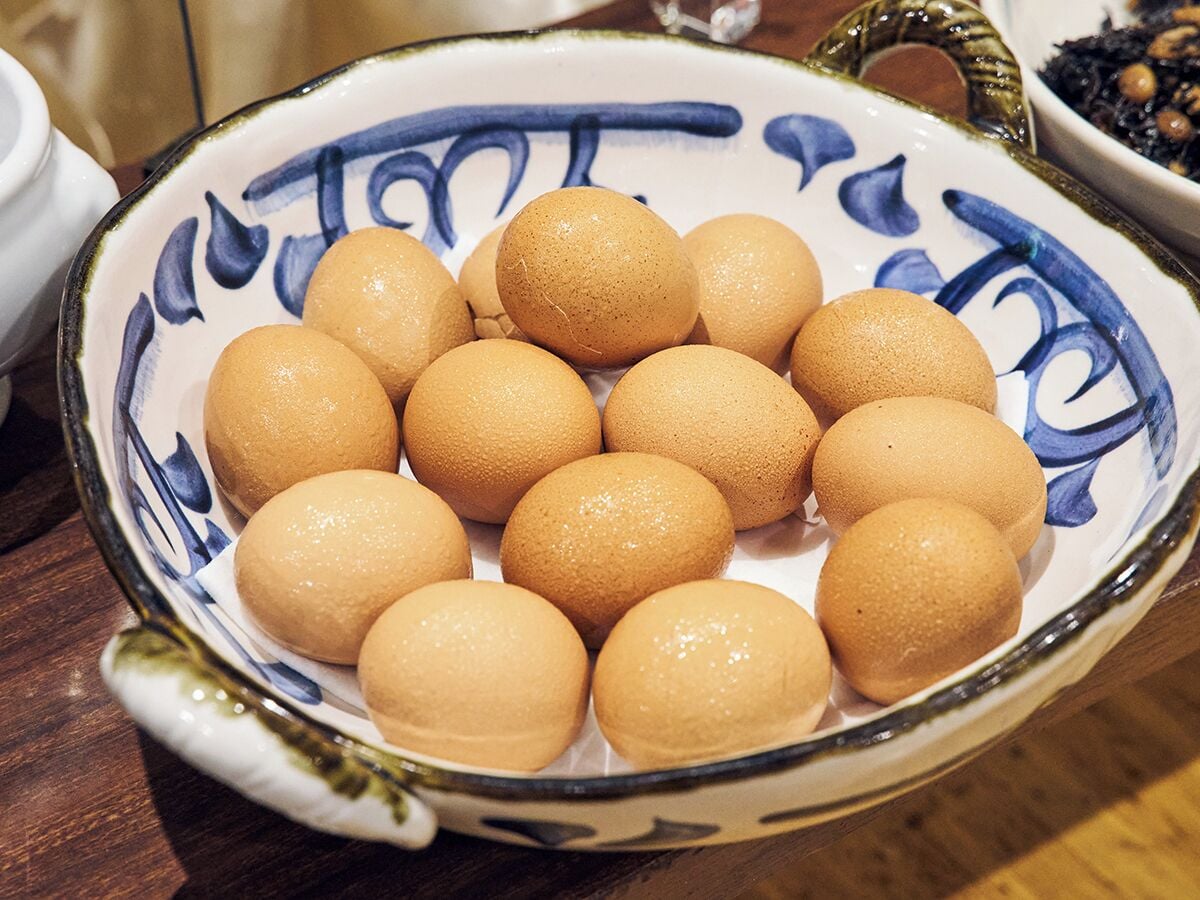 A bowl of round, brown eggs on a table.