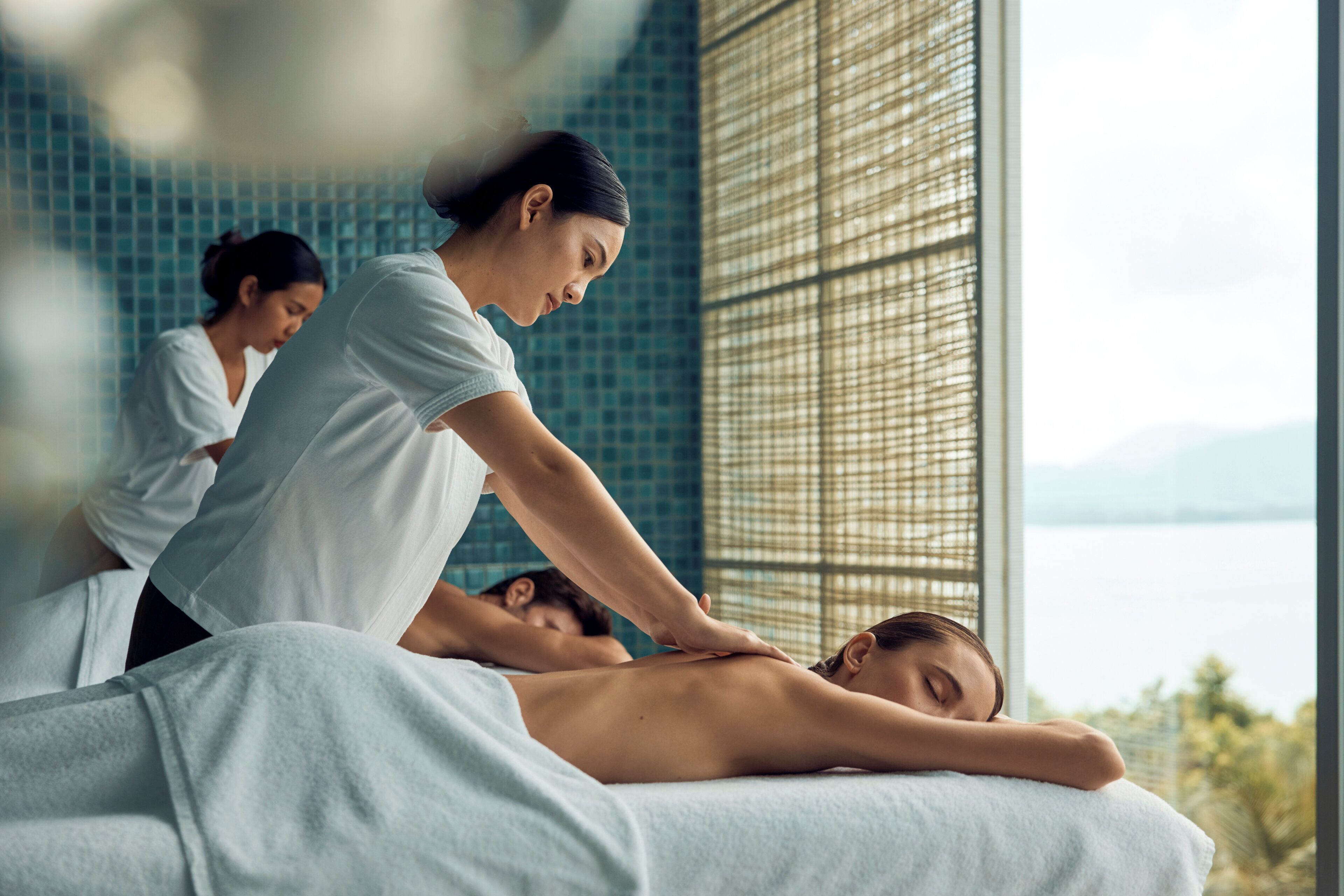 Sesión de masoterapia en una habitación con vista a un cuerpo de agua.
