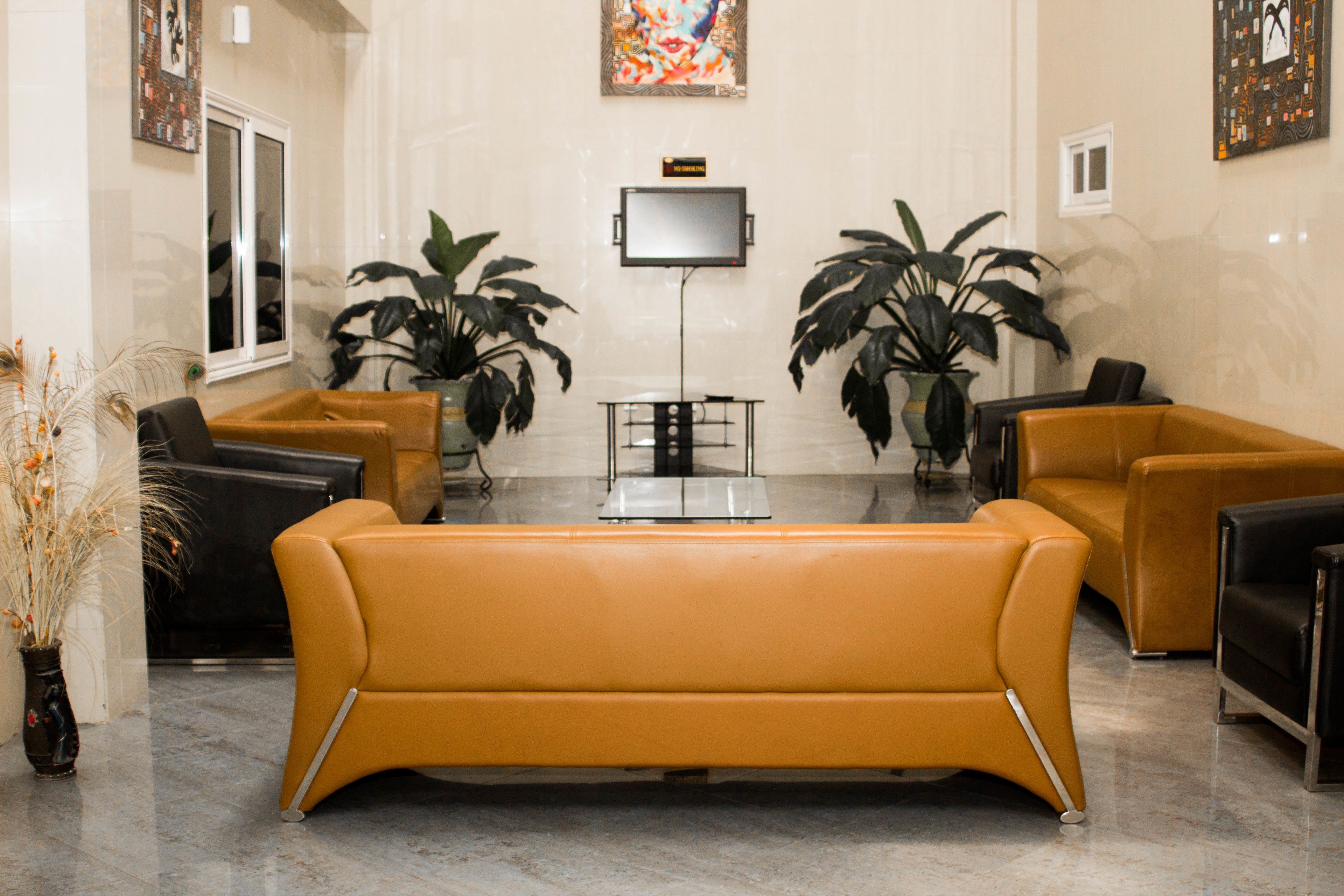 Una sala de estar moderna con un sofá, sillones y un televisor de pantalla plana.