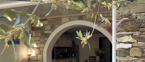 An interior with a stone wall, a kitchen, and a living area with a sofa and a coffee table.
