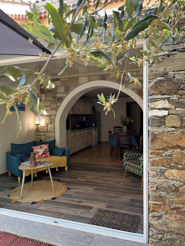 An interior with a stone wall, a kitchen, and a living area with a sofa and a coffee table.