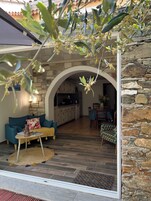 Um interior com parede de pedra, cozinha e sala de estar com sofá e mesa de centro.