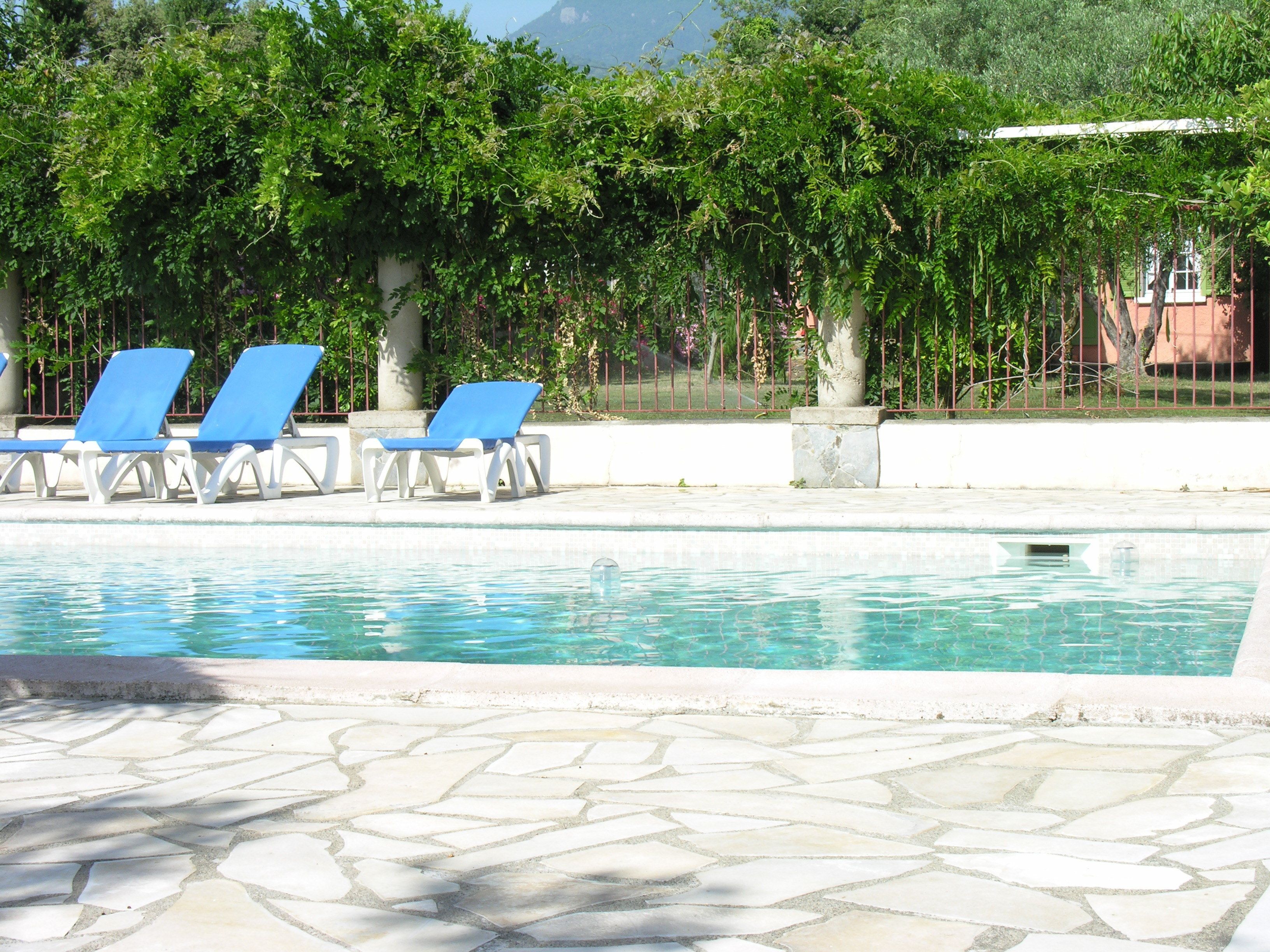 Una piscina al aire libre, sillones reclinables de piscina