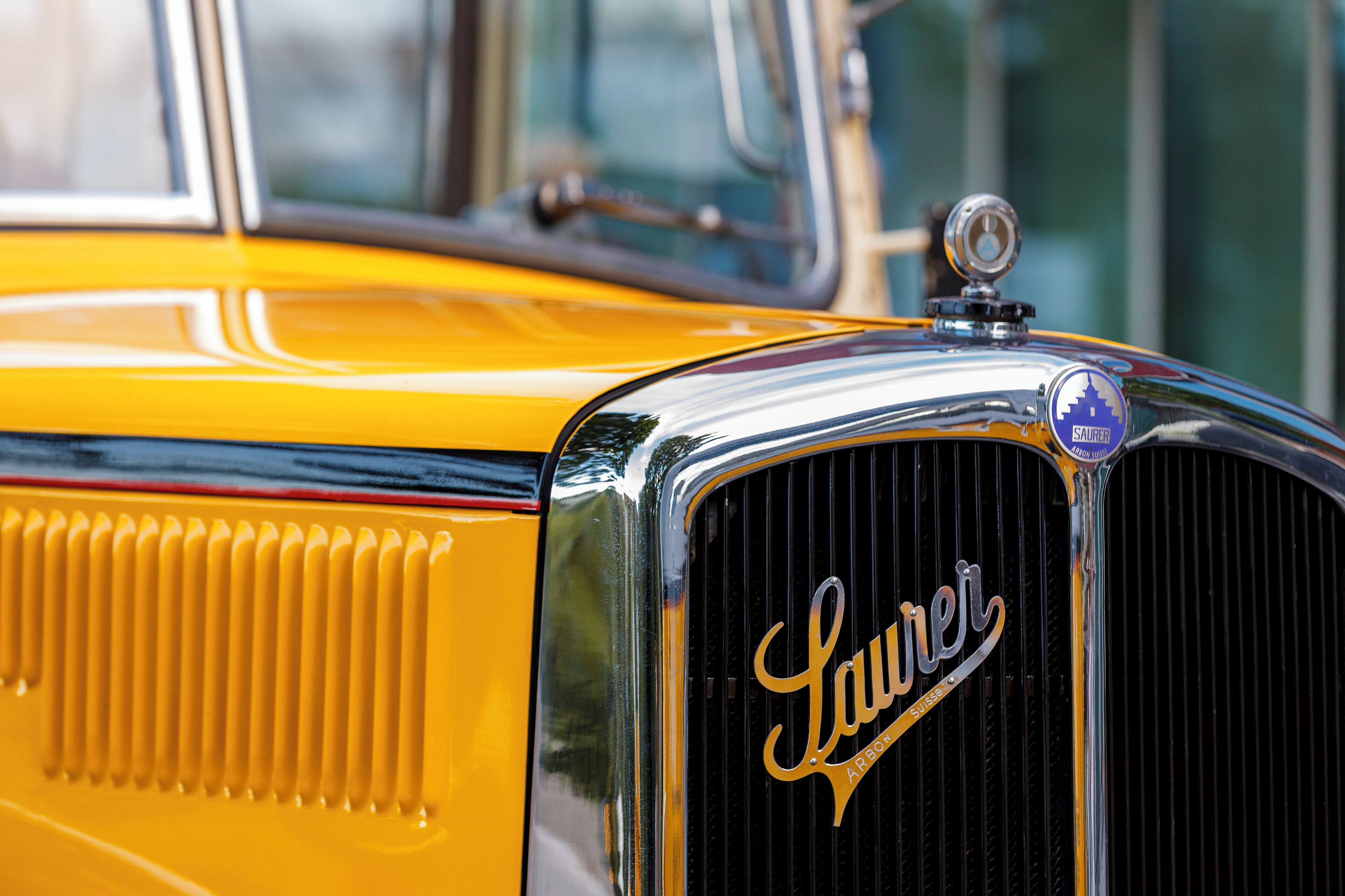 A close-up of a vintage car's front grille with the brand 'Laurel' and a city emblem.