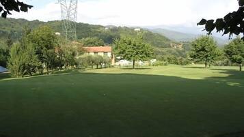 Enjoy a serene golfing experience amidst lush trees and rolling hills.