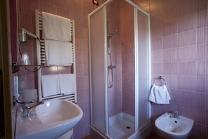 A bathroom with a shower, two sinks, and striped wallpaper. - Cà del Moro Resort (Pontremoli)