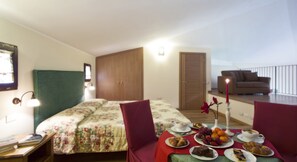 A bedroom with a bed, bedside table, and a balcony with a sofa. - Cà del Moro Resort (Pontremoli)