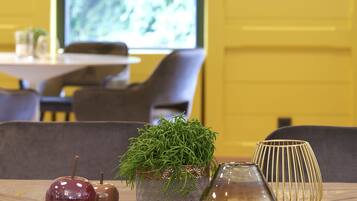 Una mesa con dos manzanas, una planta en maceta y una jarra de cristal en un restaurante.