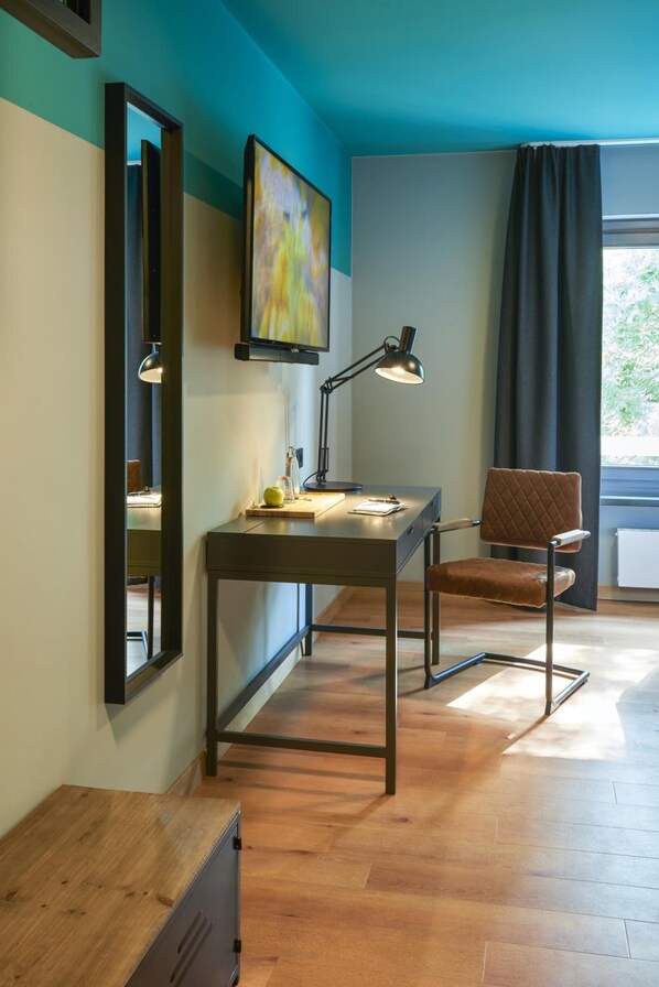 Una habitación moderna con escritorio, silla y un espejo grande.