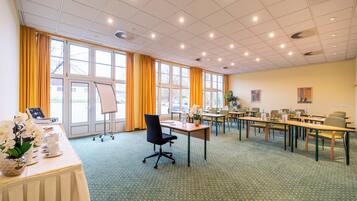 A conference room with a large table, chairs, and a projector screen.