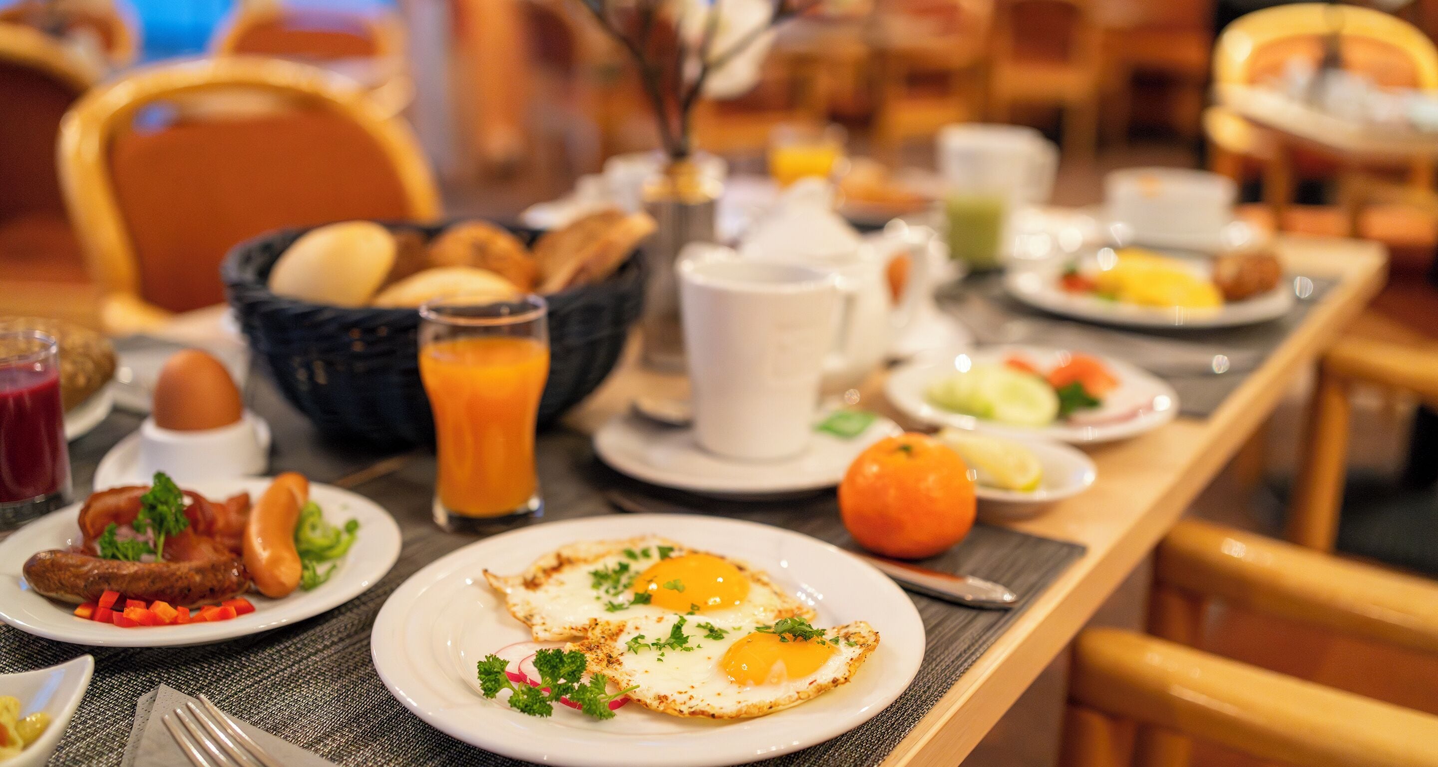 A breakfast buffet with various dishes including eggs, toast, and fruit.