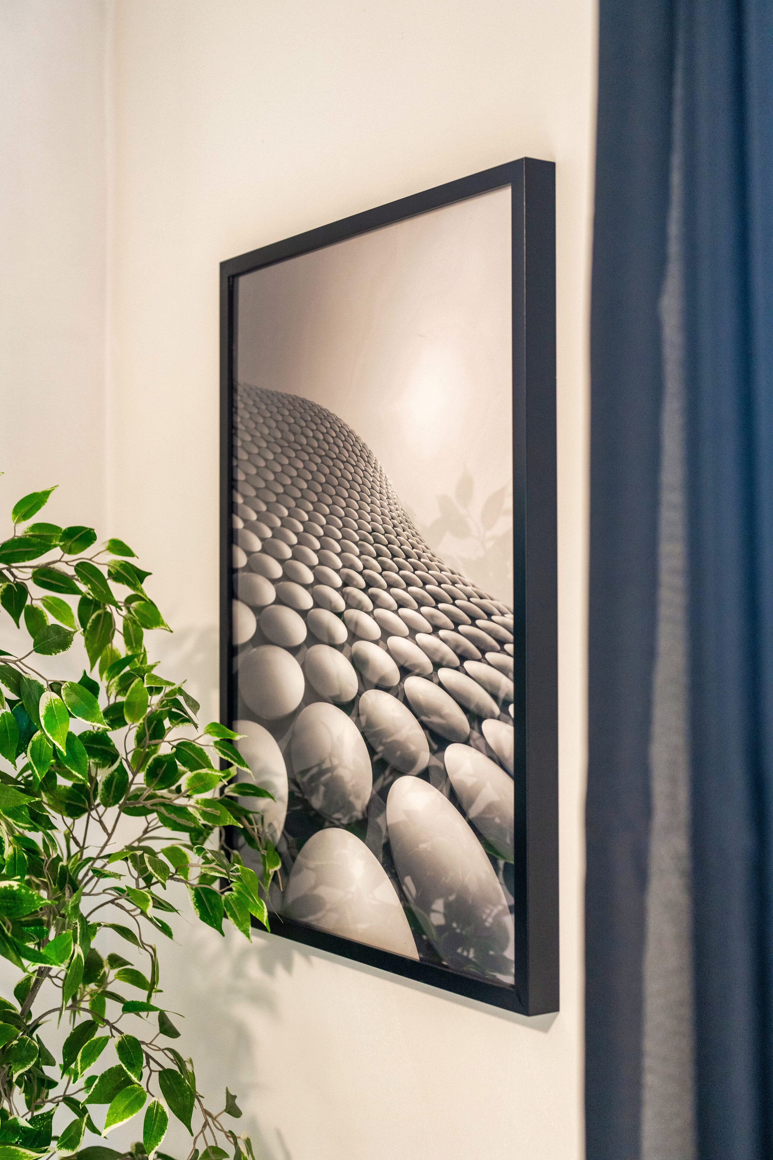 A framed artwork of smooth, rounded stones on a wall.