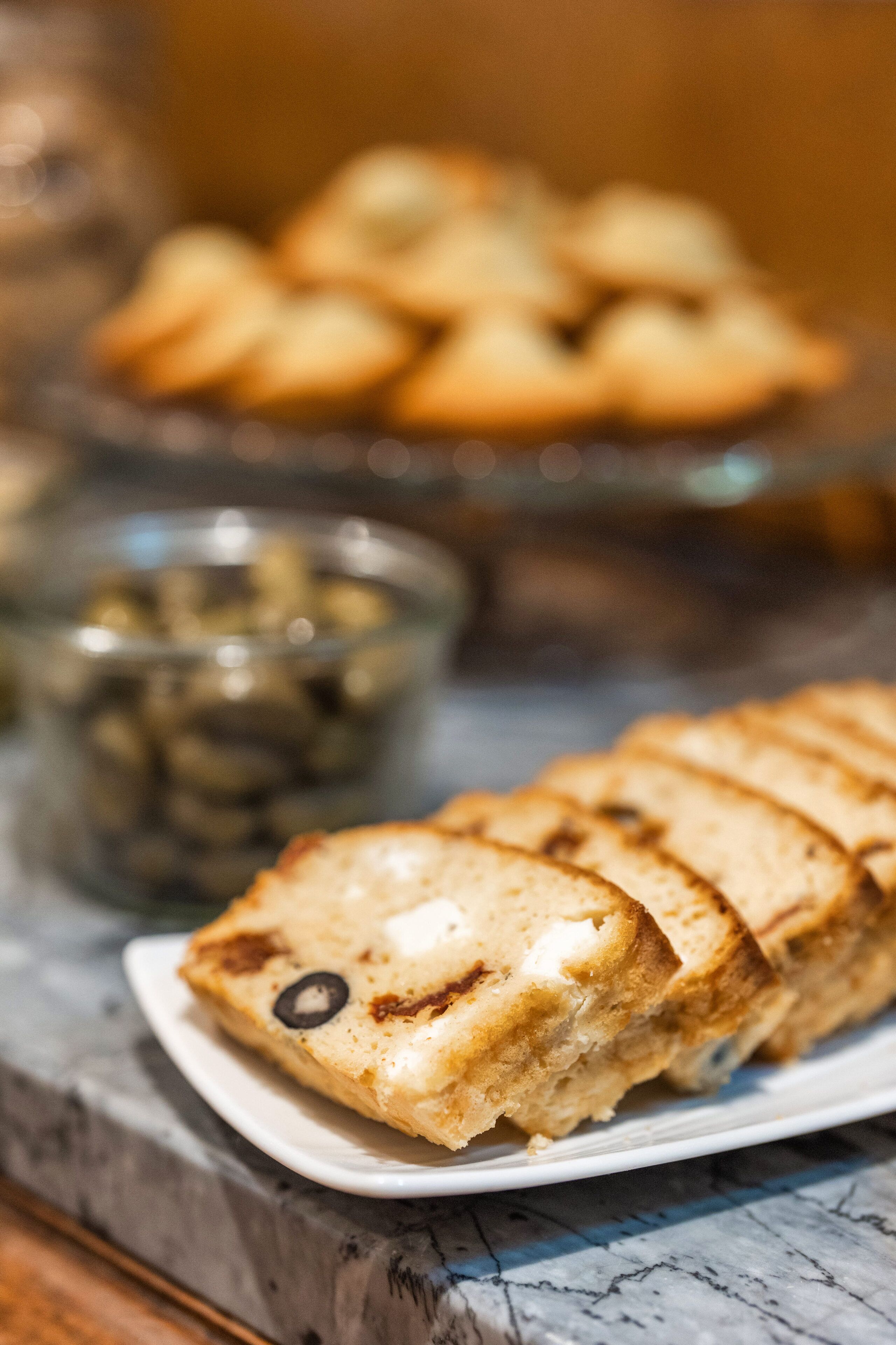 Een bord met plakjes brood, waarvan een olijf zichtbaar is.