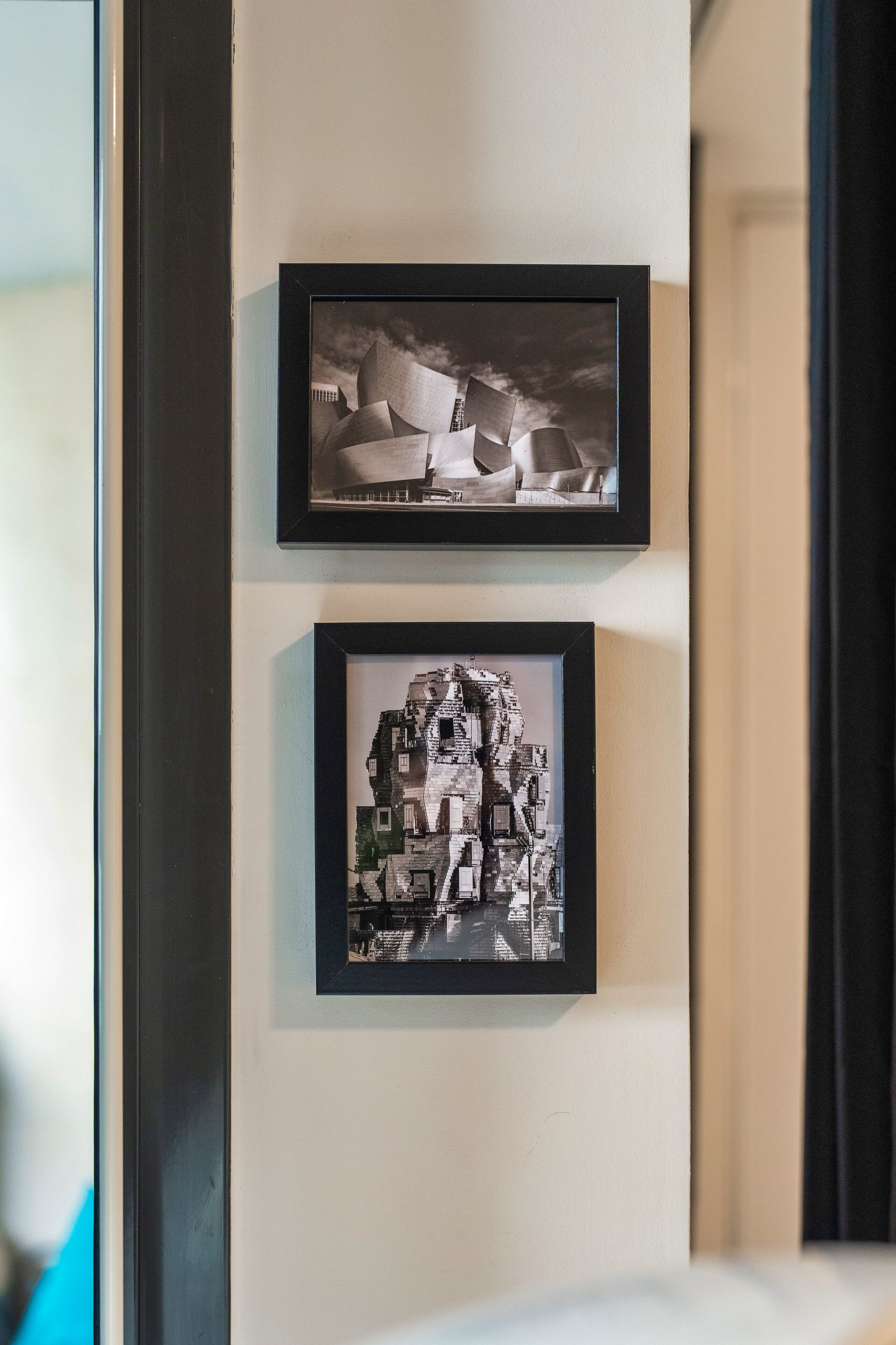 Two framed photographs of architectural structures on a wall.