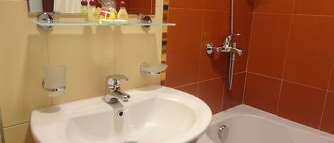 A bathroom with a white sink, a mirror, and a shower.
