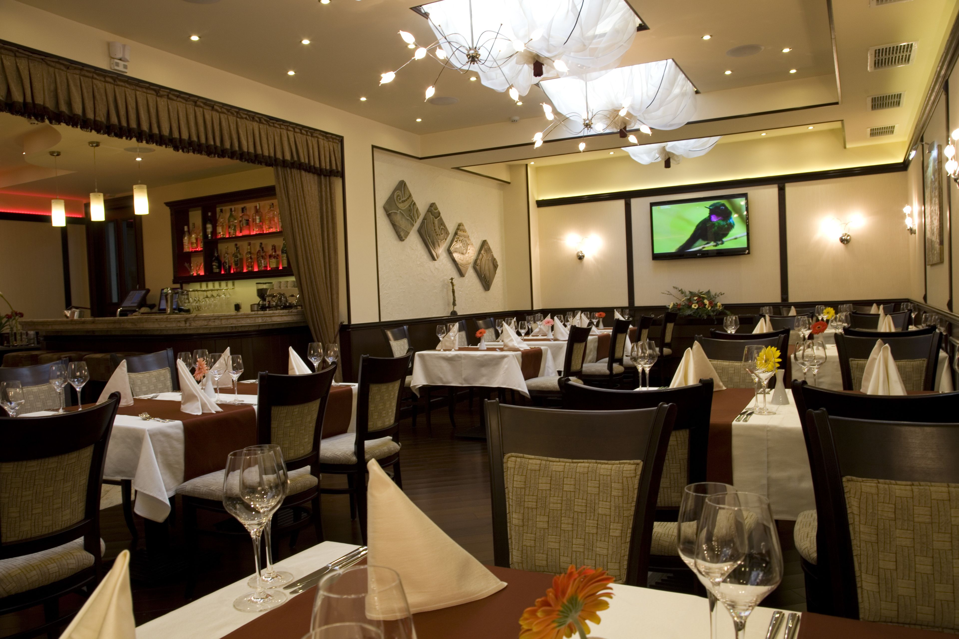 A restaurant with multiple tables, chairs, and a bar area.