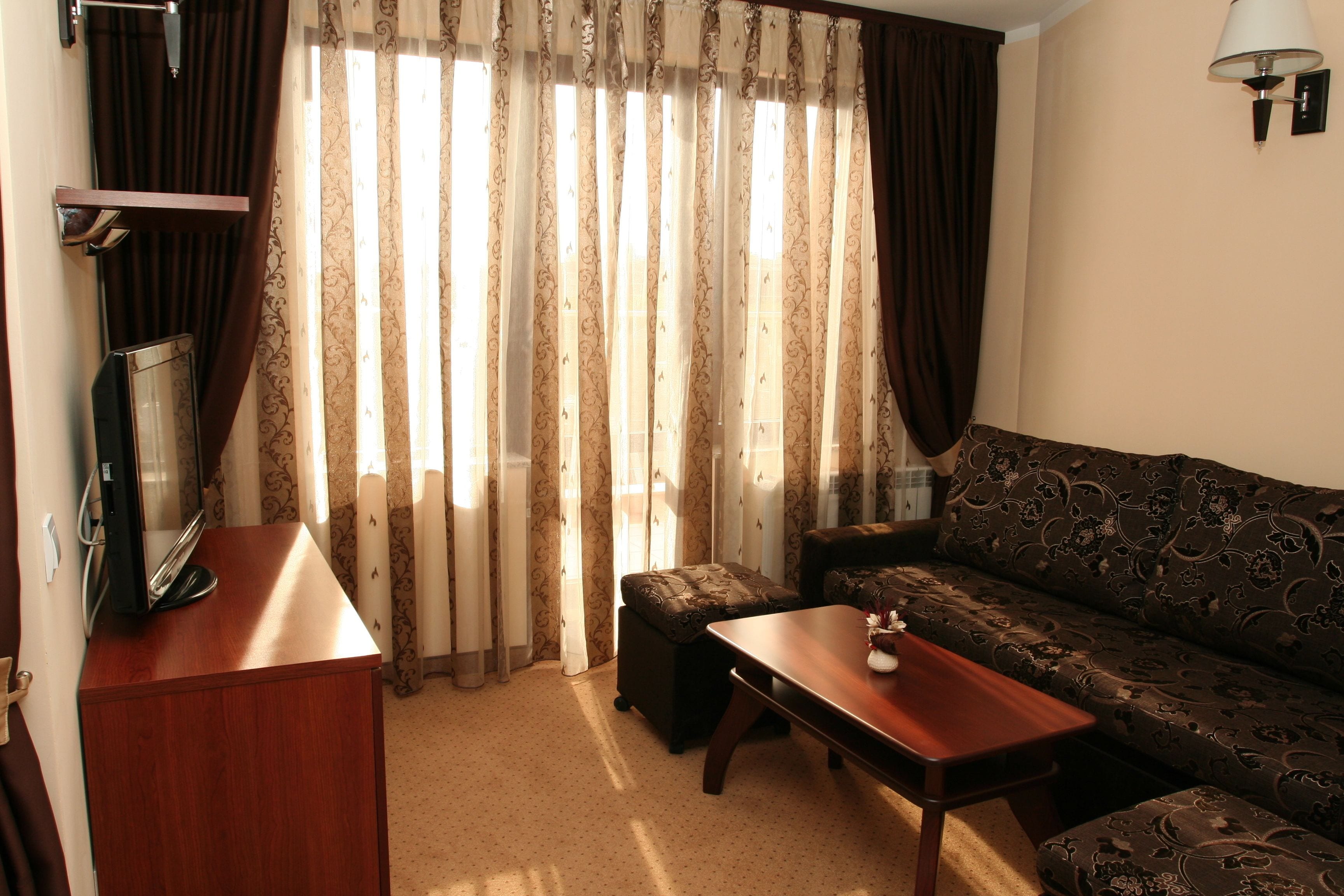 A living room with a sofa, a coffee table, a TV on a stand, and a lamp.