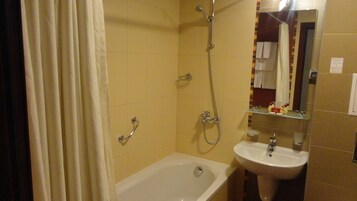 Un baño con bañera, lavabo y ducha.