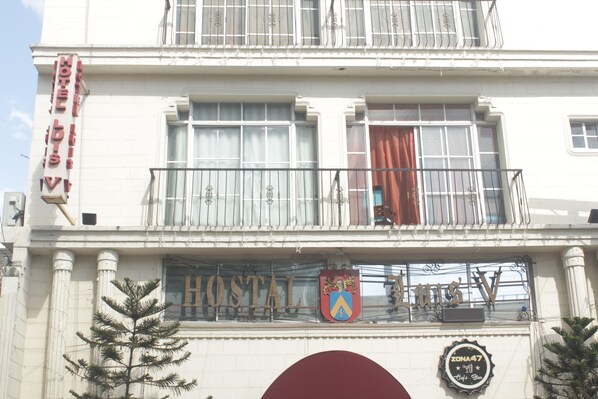 A hotel with a sign reading "HOTEL LIONS V" and a coat of arms above the entrance. - Hotel Luis V (Santo Domingo)