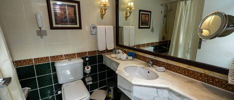 Un baño con inodoro, lavabo y espejo.