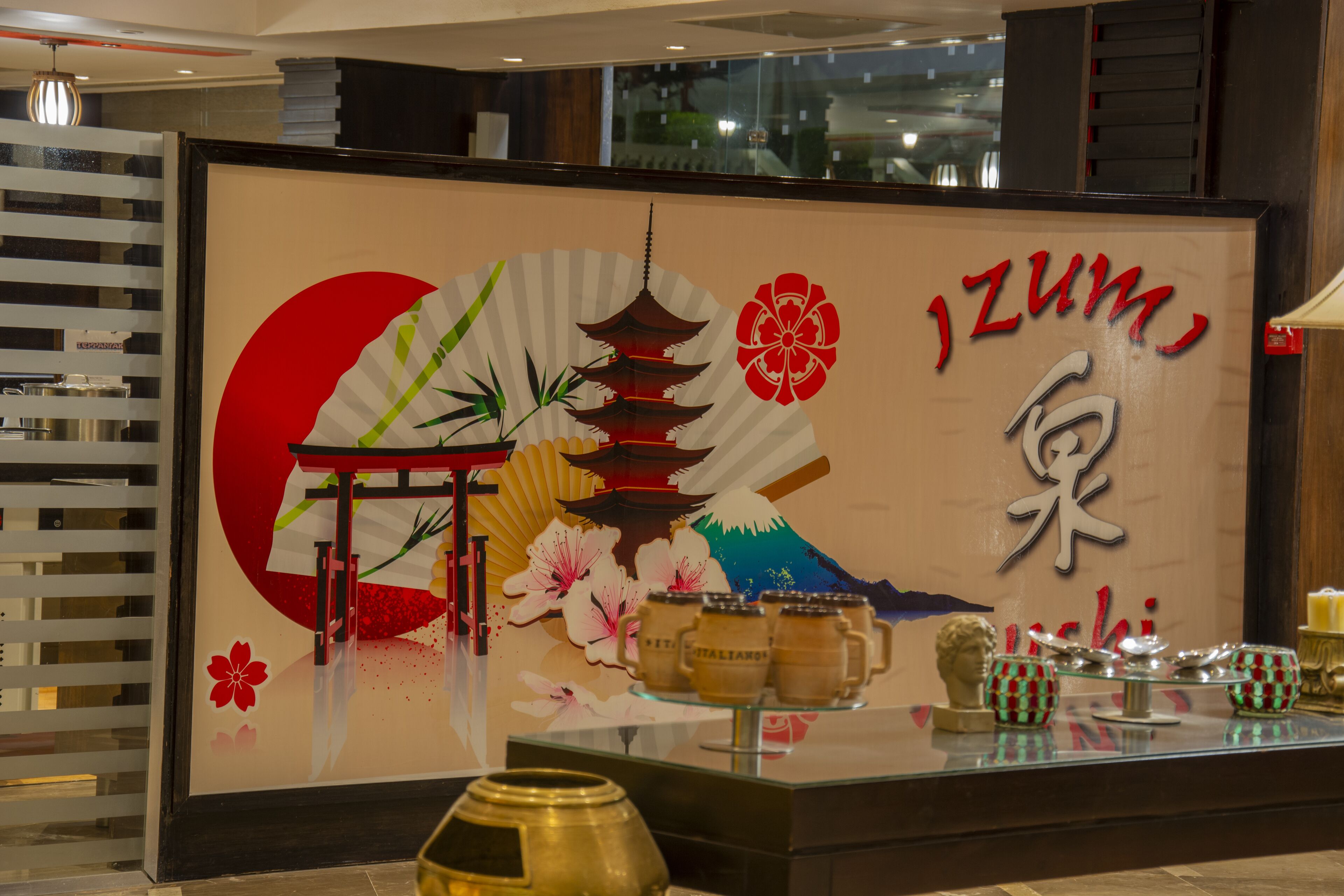 Un área de recepción con diseño tradicional japonés, que incluye un abanico grande, una pagoda y flores de cerezo.