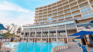 Um hotel com uma piscina grande, várias varandas e um design arquitetônico moderno.