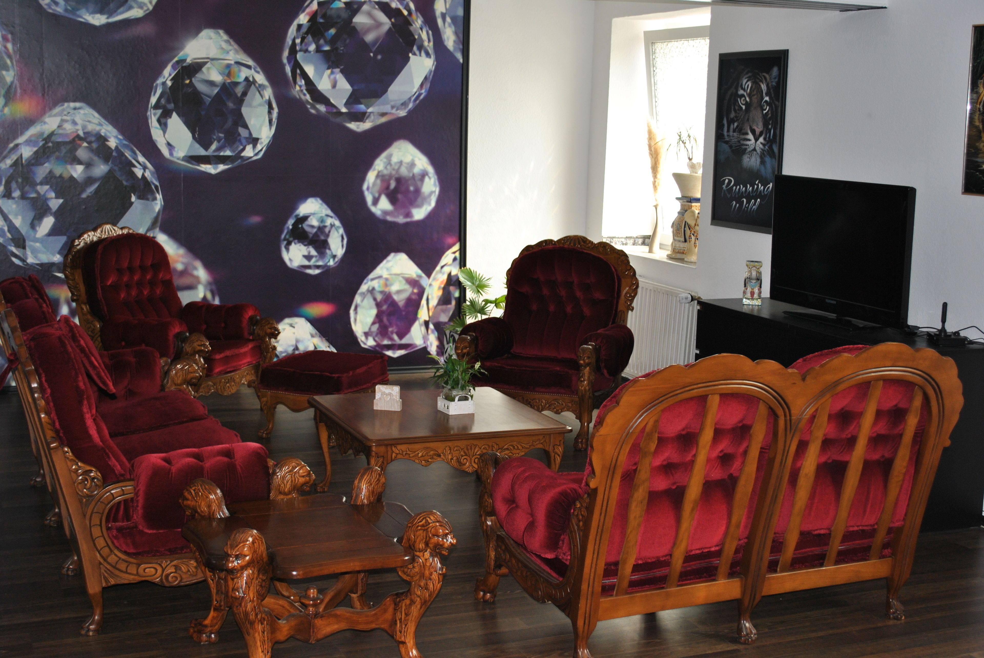 Ein Wohnzimmer mit einer großen Wandmalerei von Diamanten, einem Fernseher und einem Kamin.
