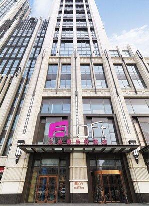 A modern hotel building with a prominent logo and signage indicating it is a Dalian hotel. - Aloft Dalian (Dalian)