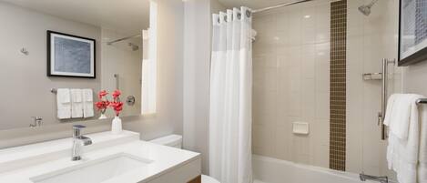 Een moderne badkamer met een groot wastafel, toilet en bad.