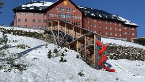 Edificio de una estación de esquí con un telesilla y paisajes nevados.