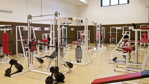 Un gimnasio con diversas máquinas de ejercicio y equipo de levantamiento de pesas.