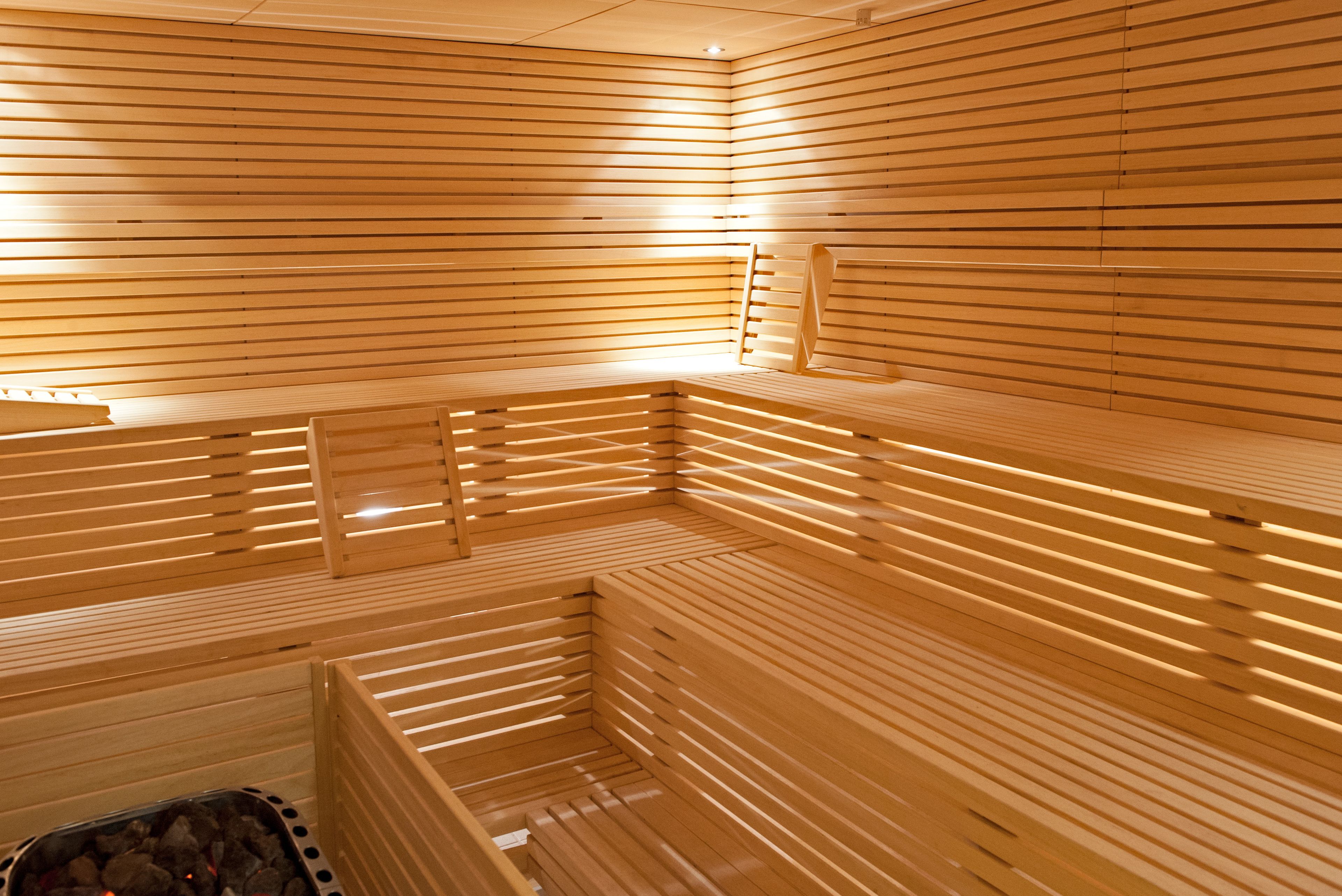 Eine Sauna mit Holzlamellen und Bänken.