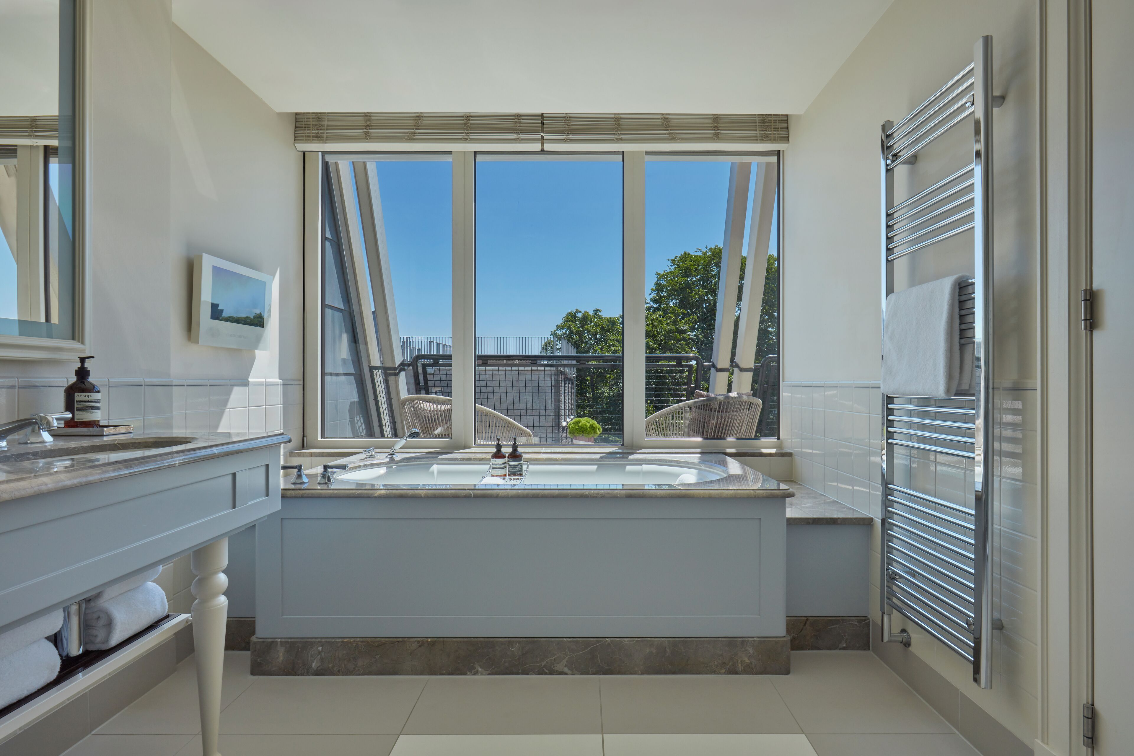 Ein modernes Badezimmer mit großem Fenster, einer Badewanne und einer Duschkabine.