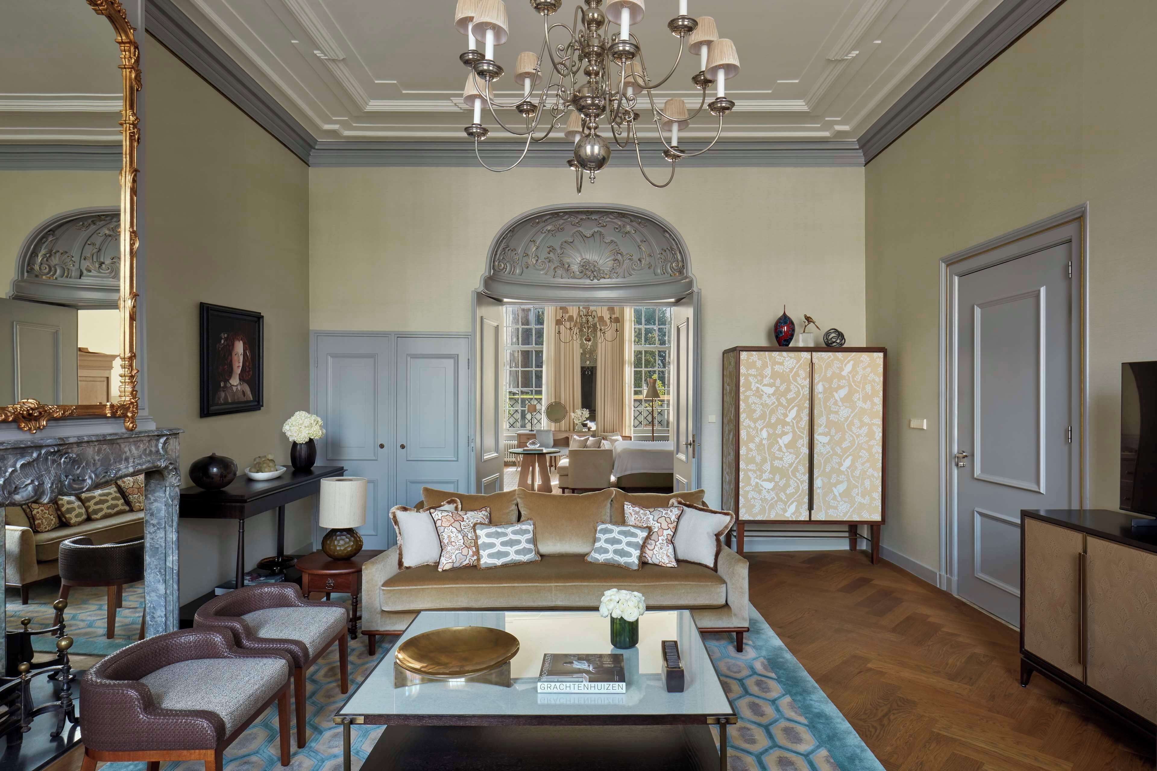 A spacious living room with a sofa, chairs, a coffee table, and a chandelier.