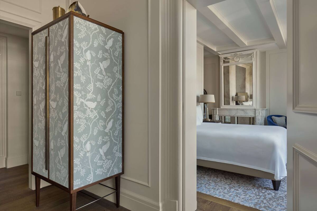 A bedroom with a large bed, a dresser, and a mirror.