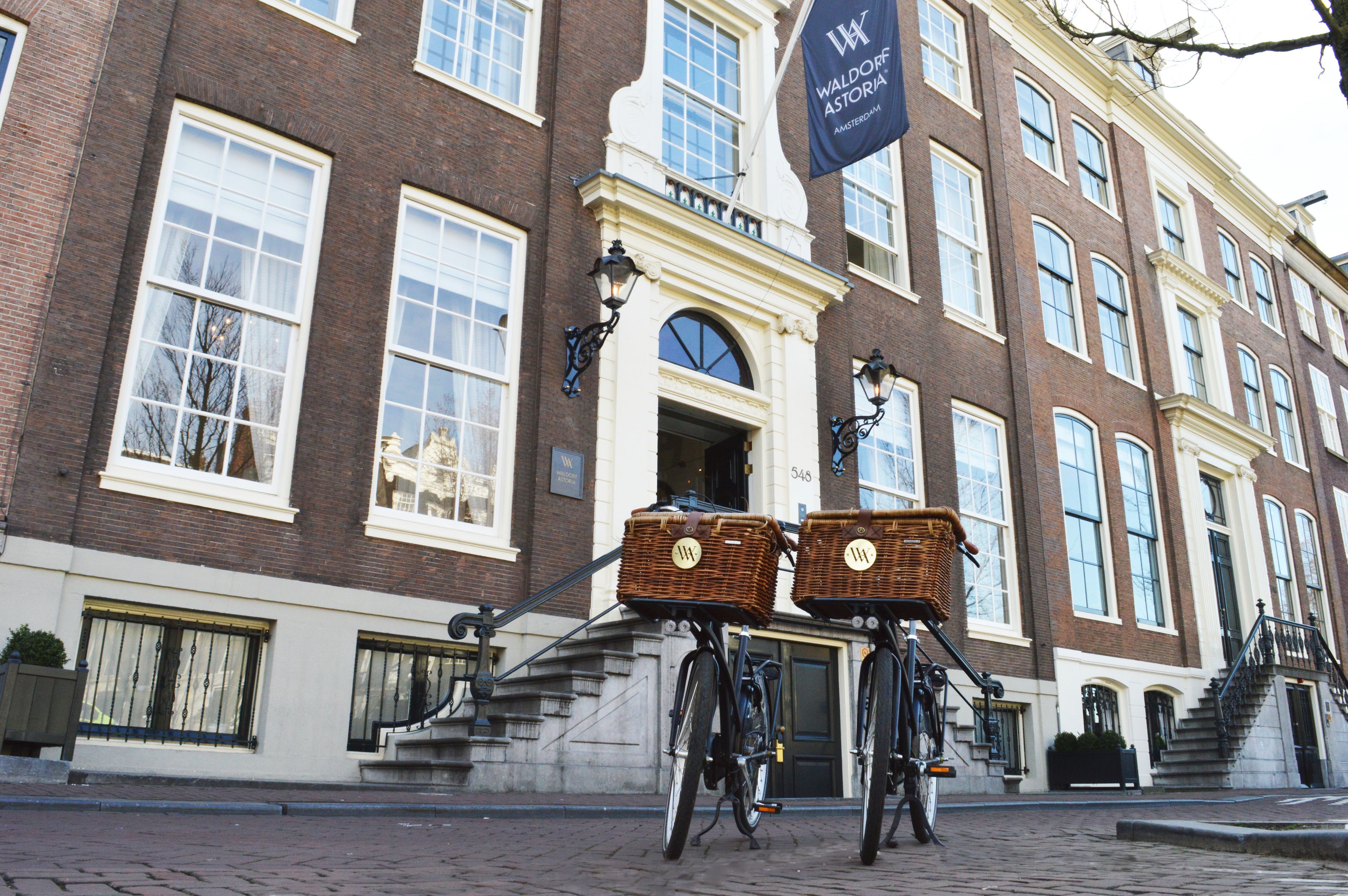 Um edifício histórico com uma placa que diz "Waldorf Astoria Amsterdam".