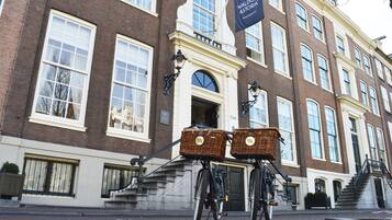 Um edifício histórico com uma placa que diz "Waldorf Astoria Amsterdam".