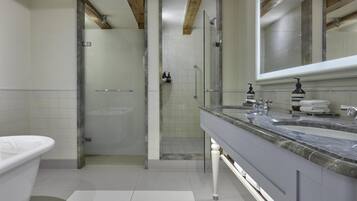 Un baño moderno con ducha de vidrio, tocador doble y un espejo grande.