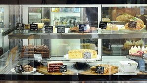 Une vitrine de boulangerie présentant diverses pâtisseries et une machine à café.