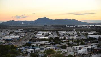 A cityscape with a mountain in the background, a highway, and various buildings.