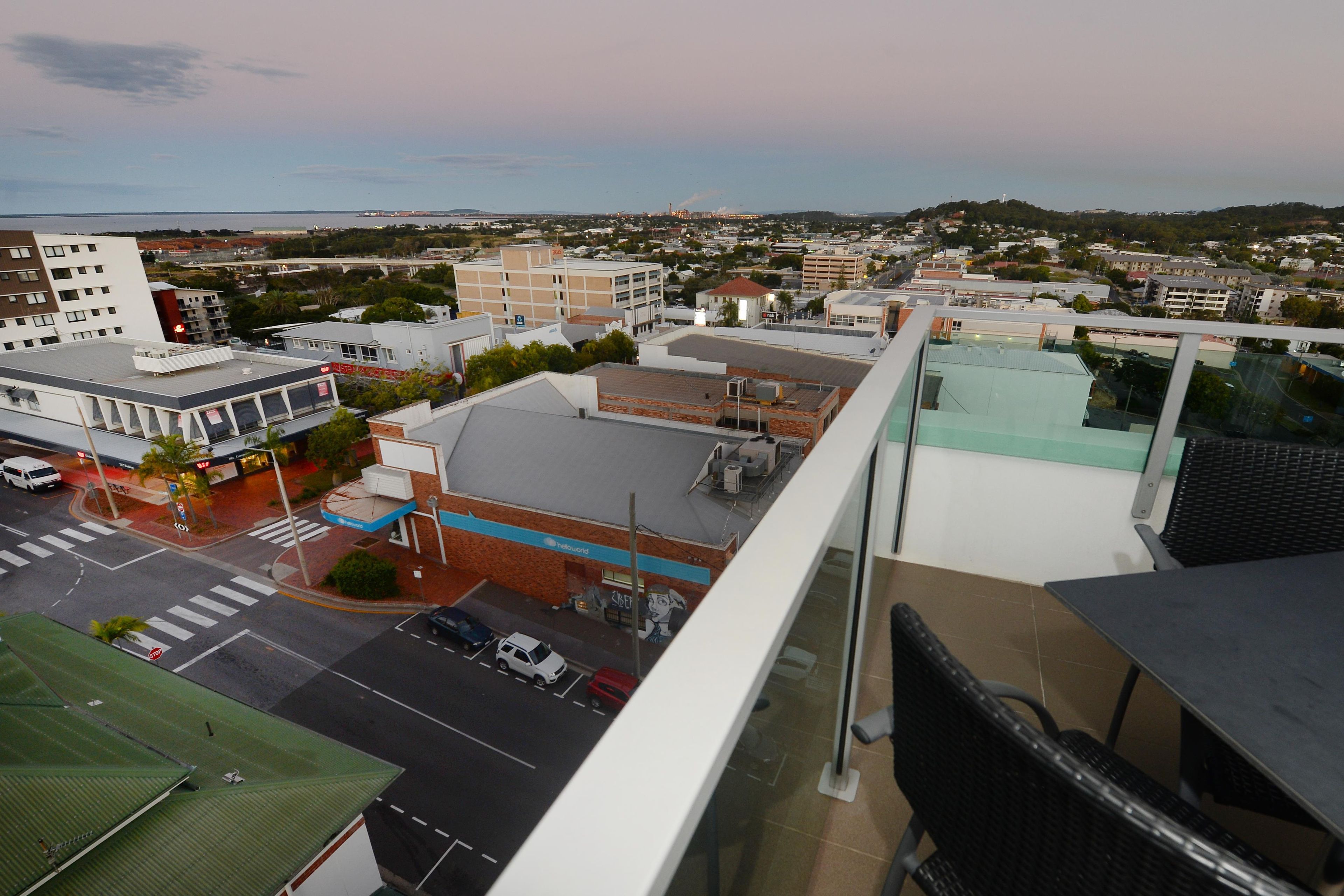 A cityscape with various buildings, a parking lot, and a clear sky.