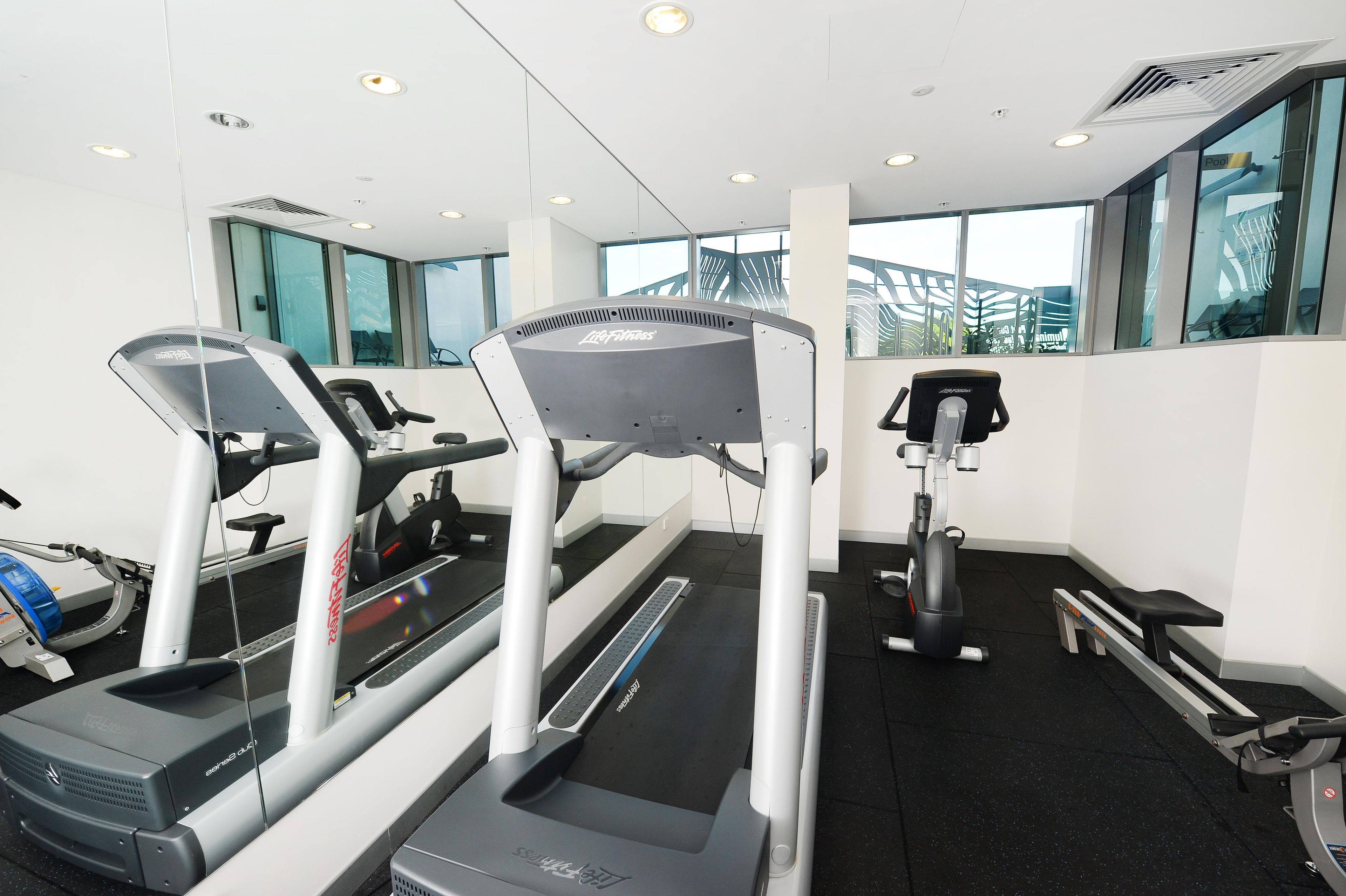 A gym with treadmills, a stationary bike, and a rowing machine.