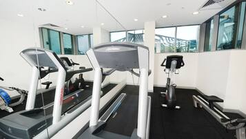 A gym with treadmills, a stationary bike, and a rowing machine.