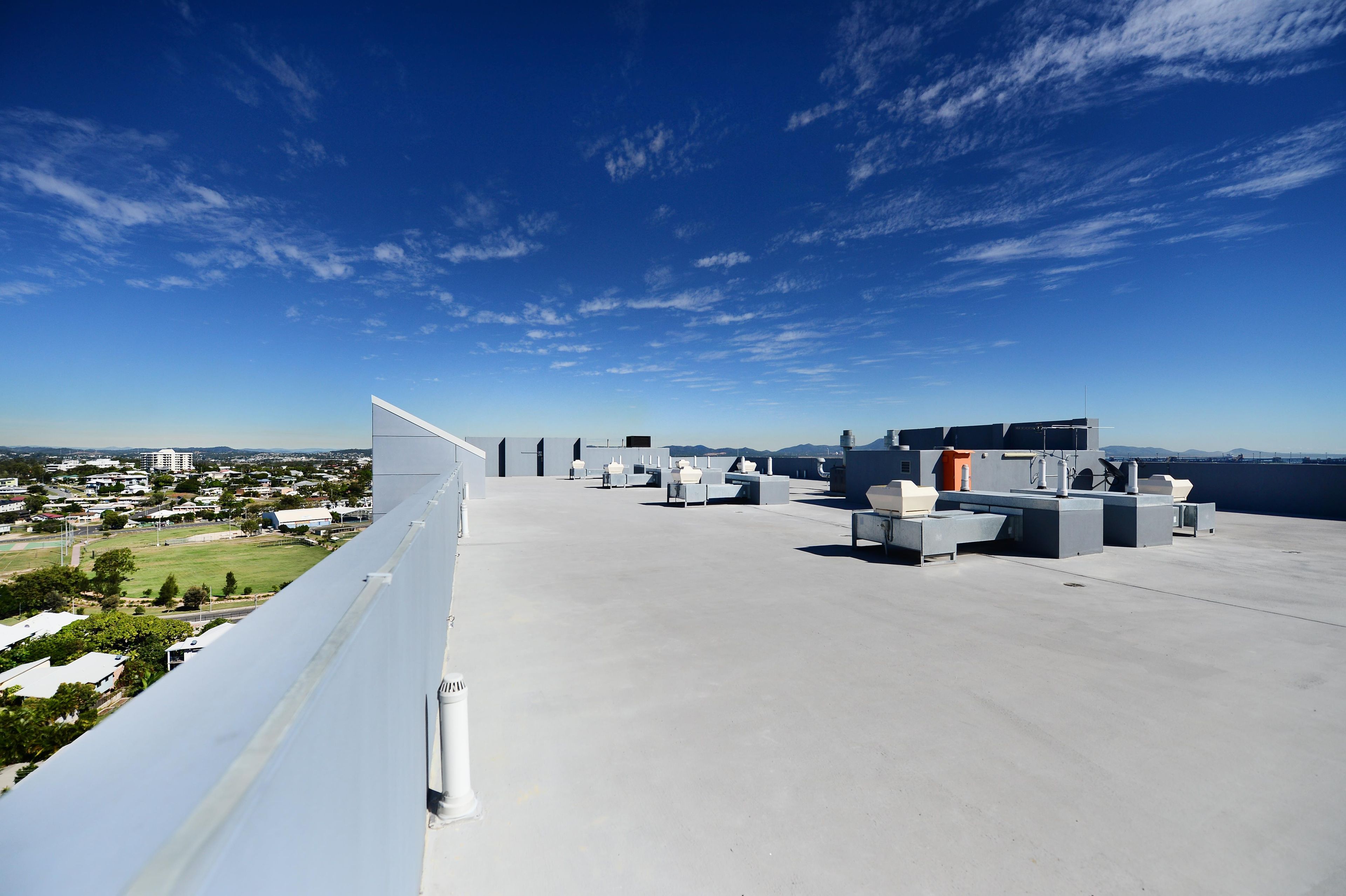 A rooftop terrace with a clear view of the cityscape, equipped with multiple air conditioning units and seating areas.