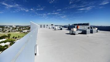 A rooftop terrace with a clear view of the cityscape, equipped with multiple air conditioning units and seating areas.
