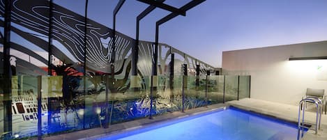 Ein Hallenschwimmbad mit Glasbarriere und Metallgeländern.