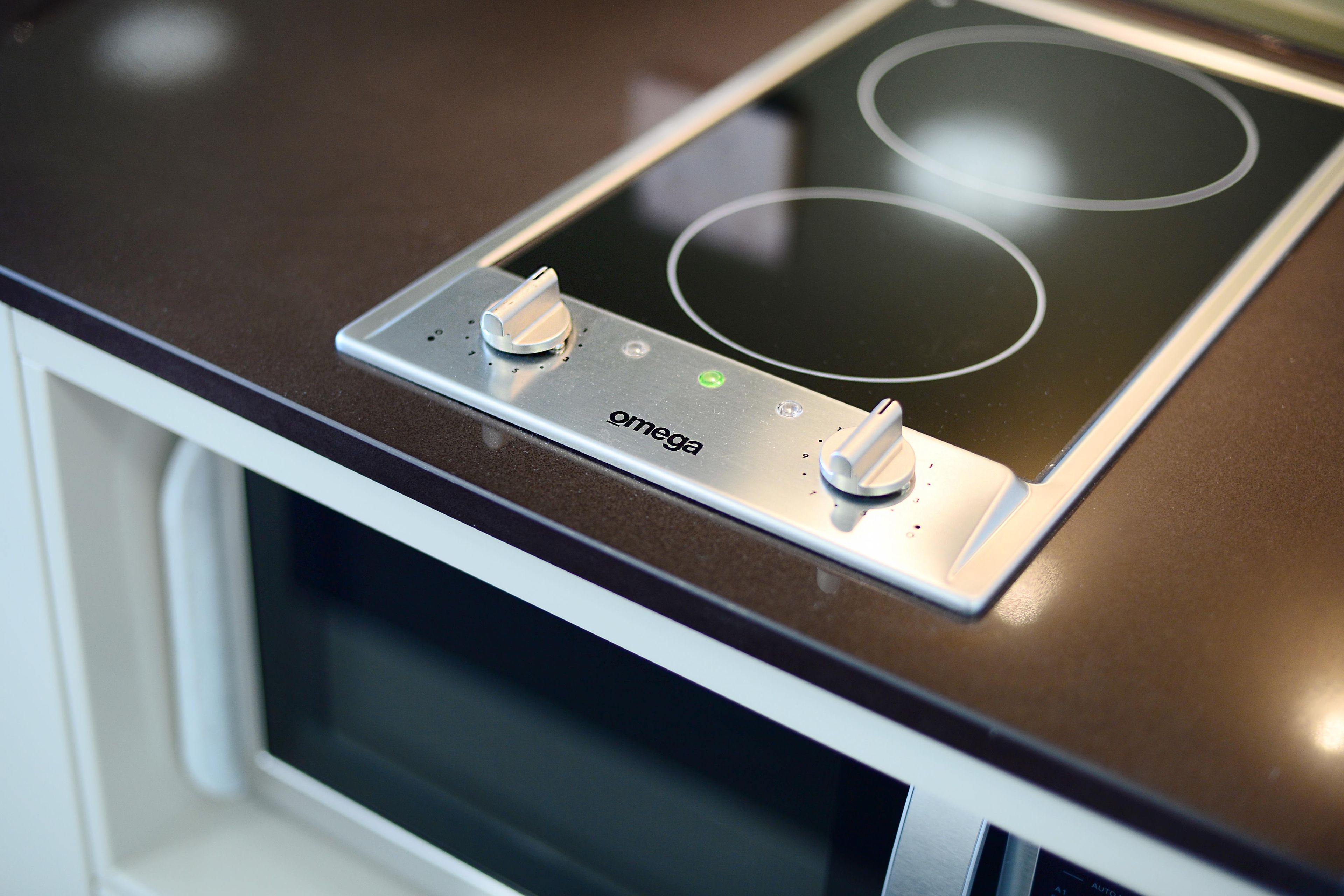 A kitchen with a built-in induction cooktop and a microwave.