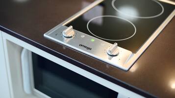 A kitchen with a built-in induction cooktop and a microwave.